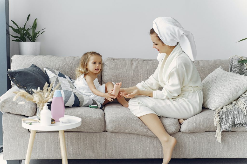 woman in white robe sitting on couch with her daughter 3985043